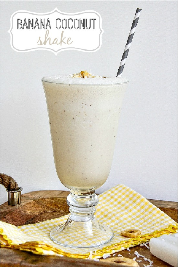 a banana coconut shake in a milkshake glass with a grey straw