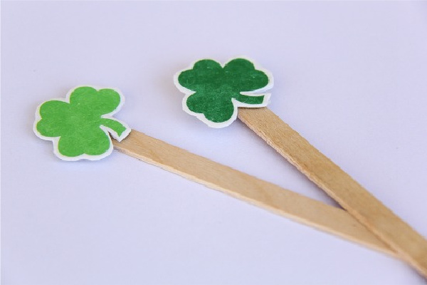 wood drink stirrers with paper shamrocks glued to them