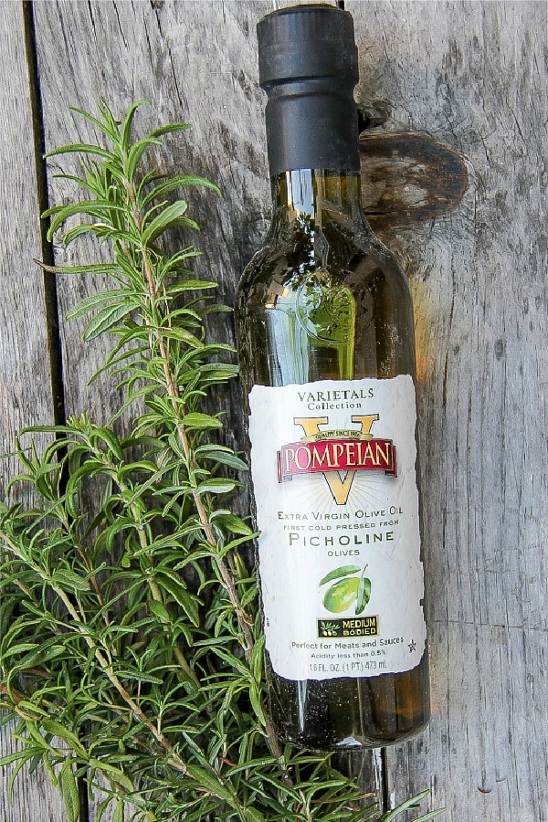 a bottle of Pompeian olive oil and a bunch of fresh rosemary