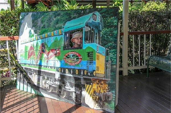 a boy taking a photo in a train photo prop at a railway station