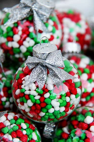 red, green, and white candy inside clear ornaments with a silver bow