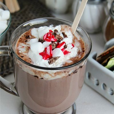 hot cocoa topped with marshmallows, candy canes, and chocolate