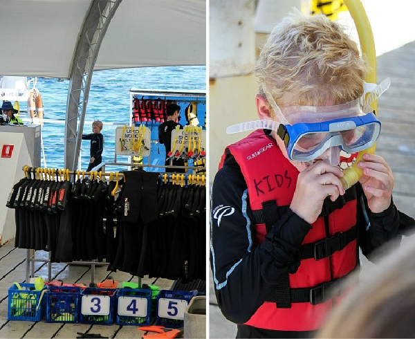 boy trying on snorkeling gear on a great barrier reef pontoon