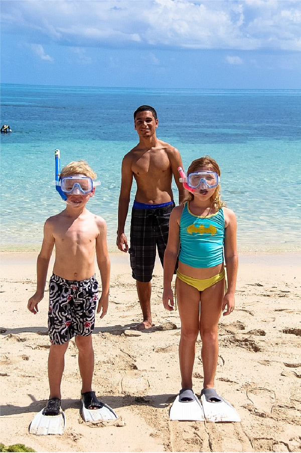 kids on the beach getting ready to snorkel off green island