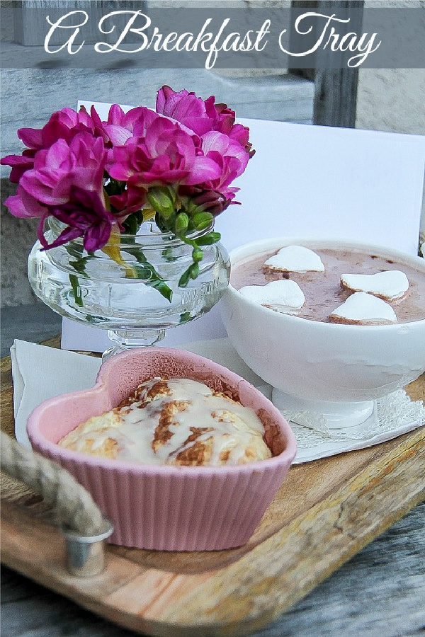 valentine's day breakfast casserole and hot chocolate with heart-shaped marshmallows, flowers, and a card on a breakfast tray