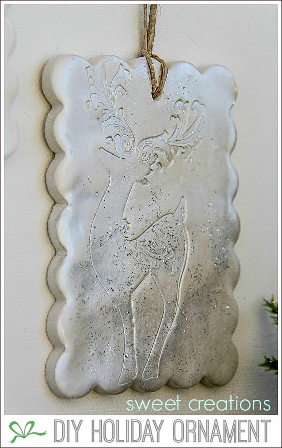 a stamped reindeer christmas ornament made out of clay and painted silver