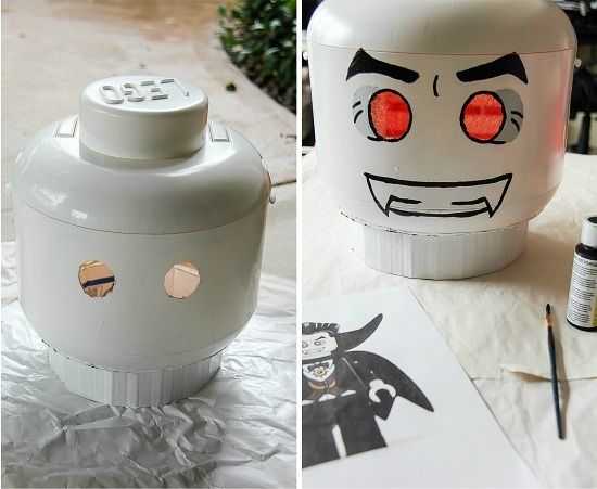 a yellow lego man storage bin painted white and turned into a vampire costume head