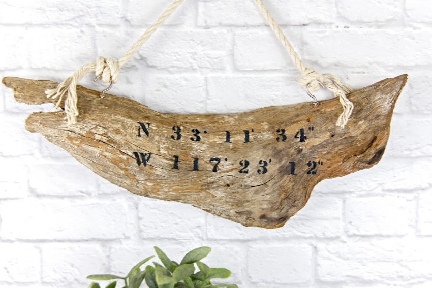 driftwood with beach coordinates on it