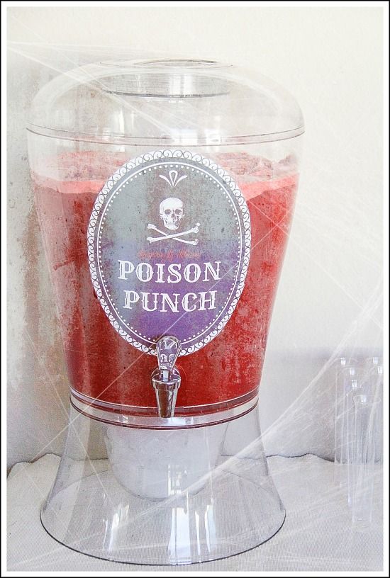 red punch in a drink dispenser with a poison punch label on it for Halloween