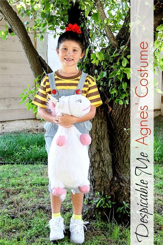 a girl wearing a Despicable Me Agnes costume and carrying a fluffy unicorn toy