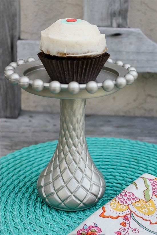 A silver cupcake stand with a Sprinkles cupcake on top.