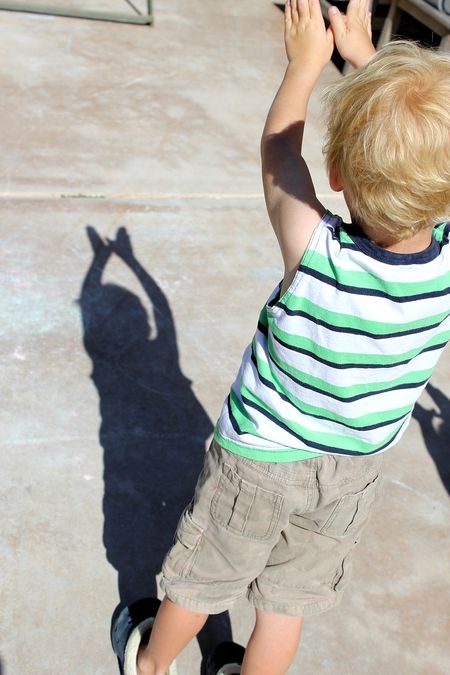 a boy making a butterfly shadow in the sun