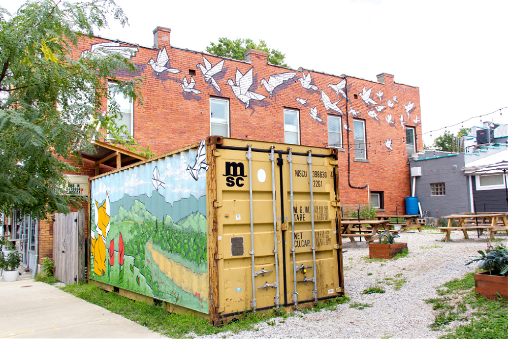 The Origami Tsunami mural by BroCoLoco and the fox container mural by The Art of Joe King at Broomwagon Bikes and Cafe in Lexington