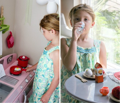 A little girl cooking eggs on her play kitchen and having breakfast together. 