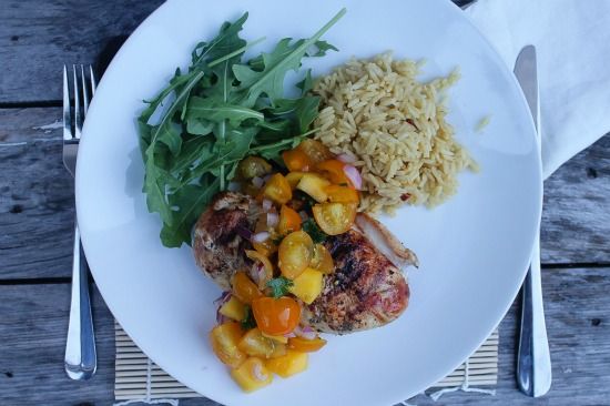 yellow tomato salsa over grilled chicken and served with rice and greens.