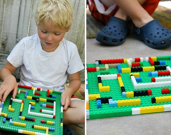 a boy playing with a LEGO marble maze