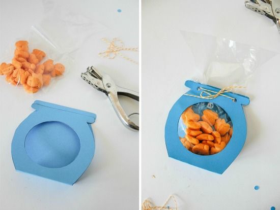 a blue paper fish bowl party bag filled with pool party fish treats for kids