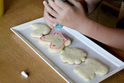 a girl decorating spring cookies with icing