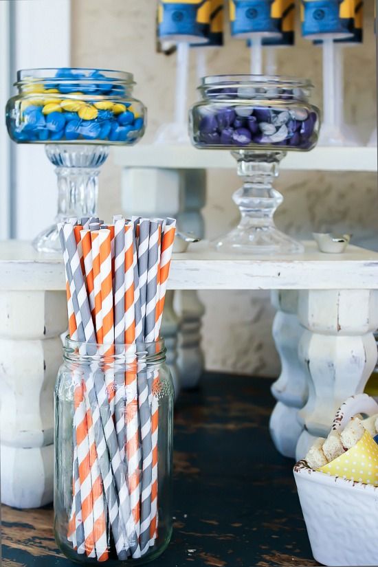 Paper straws in glass jars for a party table.