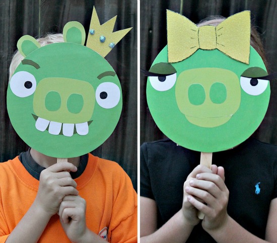 Kids holding Bad Piggies handmade photo props in front of their faces.