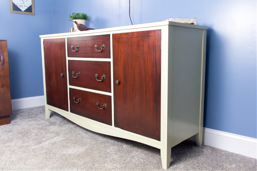 A beautiful dark wood dresser that sections of it have been painted white.