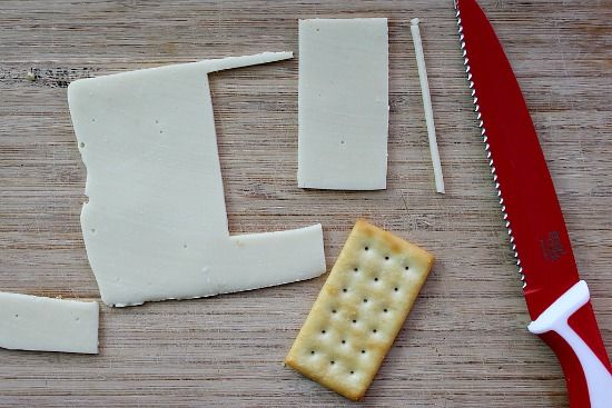 Cheese cut into rectangular slices to place on top of crackers.