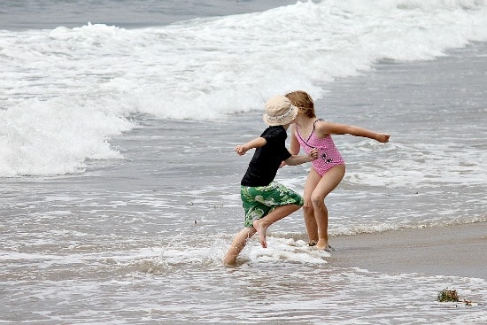 A boy and girl playing in the water at El Capitan State Beach.