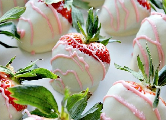 White chocolate covered strawberries with pink piped chocolate on top.
