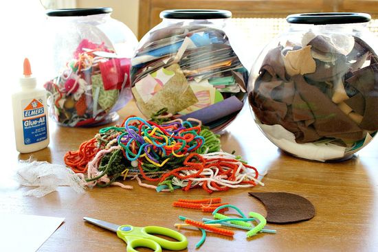 Yarn, paper, and fabric scraps stored in containers for kids to make scrap crafts.