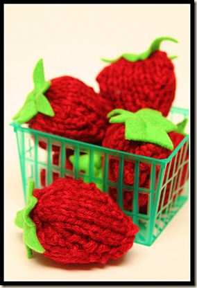 Handmade knit strawberries in a plastic punnet.