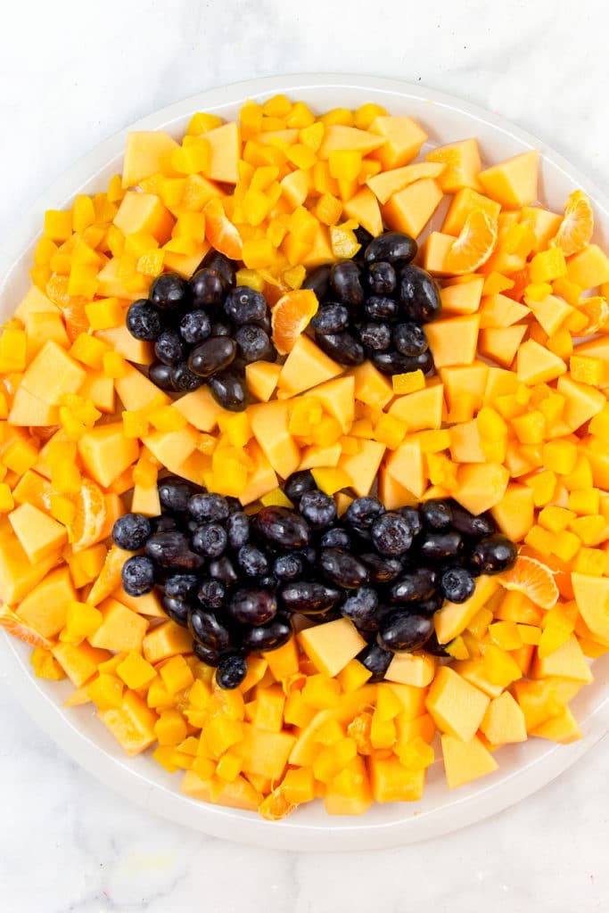 a healthy halloween fruit tray that looks like a jack o lantern