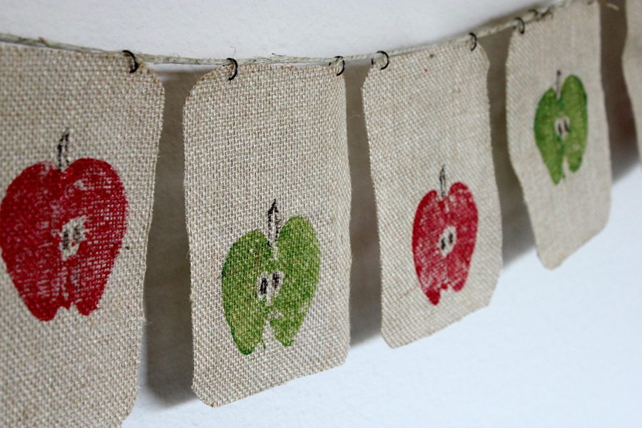 A burlap banner stamped with painted apples.