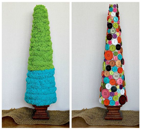 Styrofoam Christmas trees wrapped in yarn and with buttons attached to them with pins.