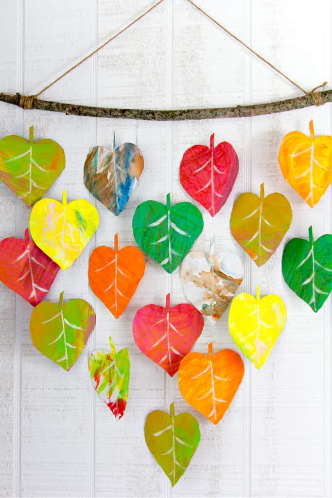 a fall leaf wall hanging using kids art cut out in the shape of fall leaves
