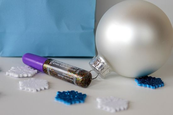 Supplies needed to make DIY glitter ornaments including sparkly stickers and glitter glue.