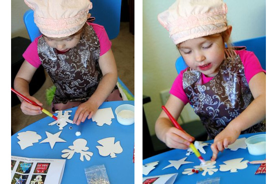 a girl decorating paper christmas ornaments