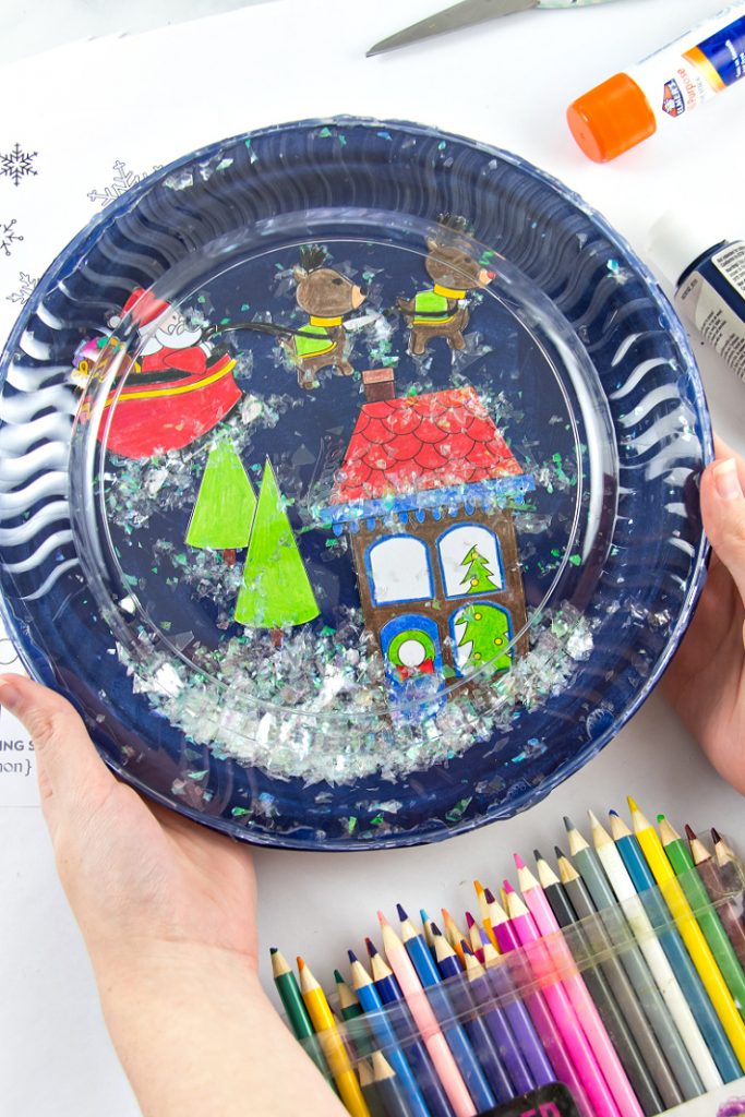 paper plate snowglobe made using a coloring page with a Christmas scene on it