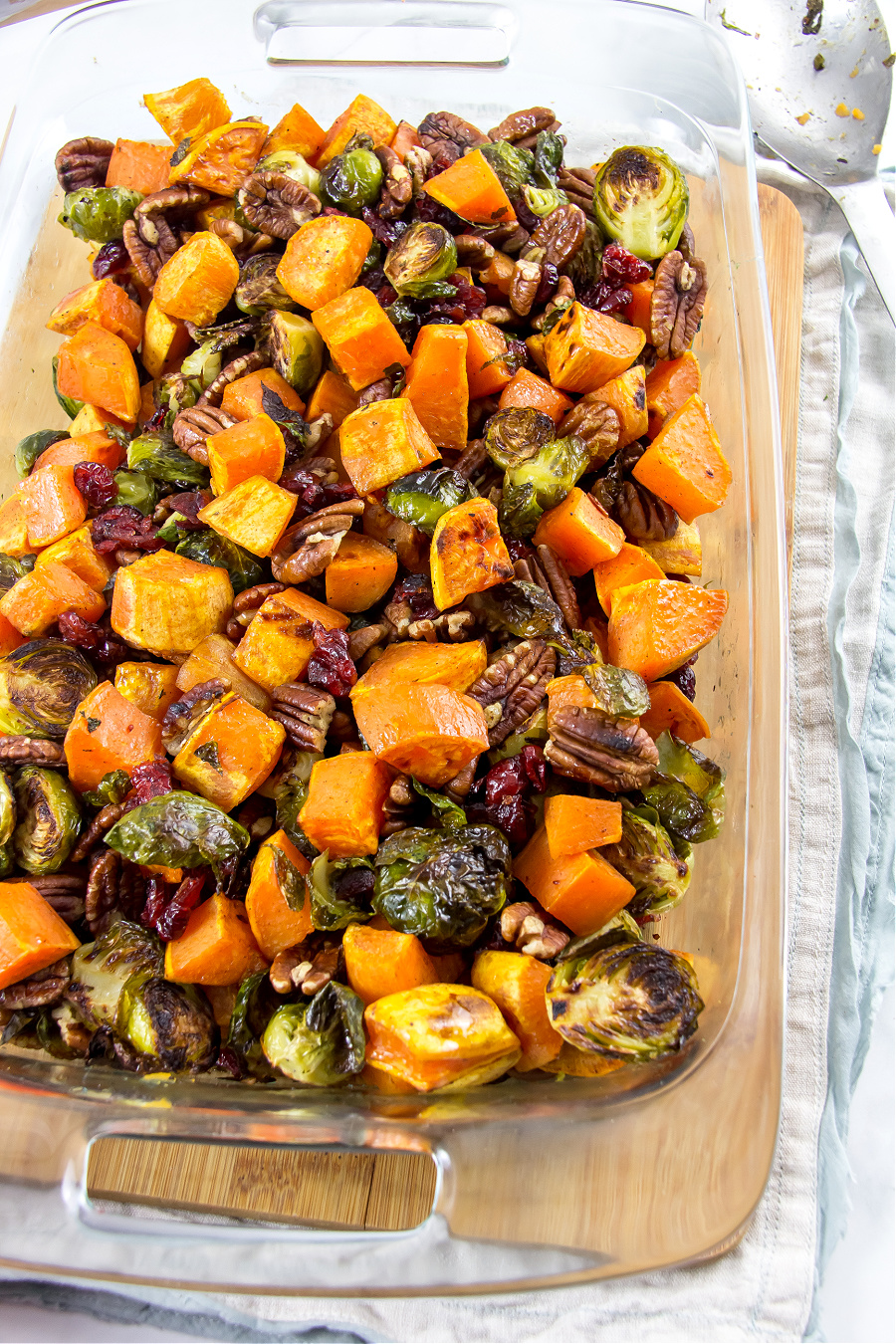 Thanksgiving side dish of roasted sweet potatoes and brussels sprouts with cranberries and pecans