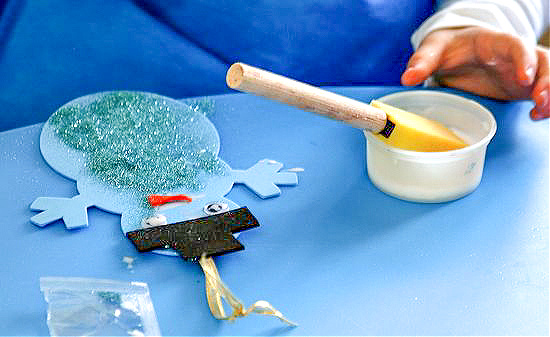 kids making snowman christmas ornaments using foam and glitter