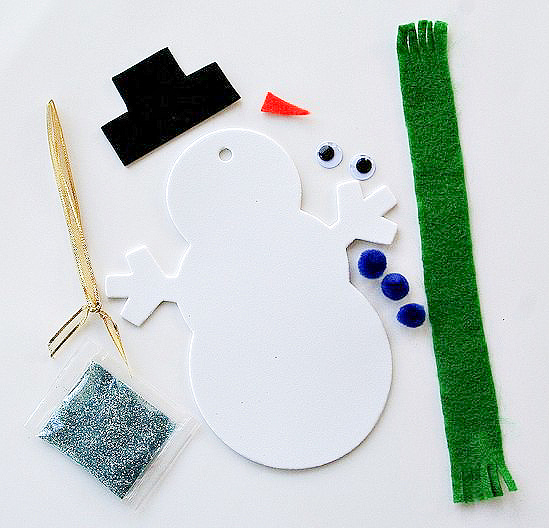 supplies to make snowman christmas ornaments including foam, felt, glitter, and pom poms.