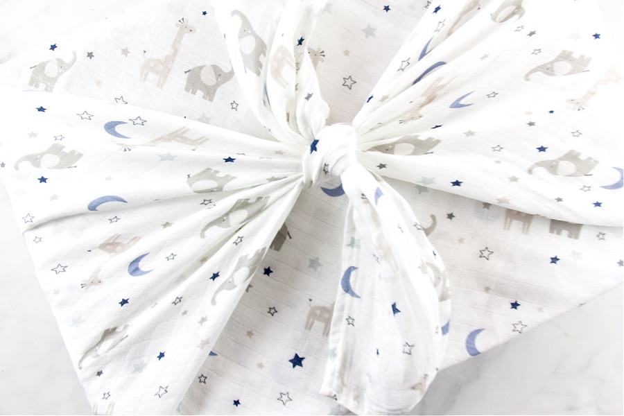 baby swaddle blanket used as gift wrap around a box for a baby shower