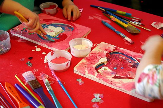 Wood picture frames from Michael's craft store being painted by kids for Valentine's Day.