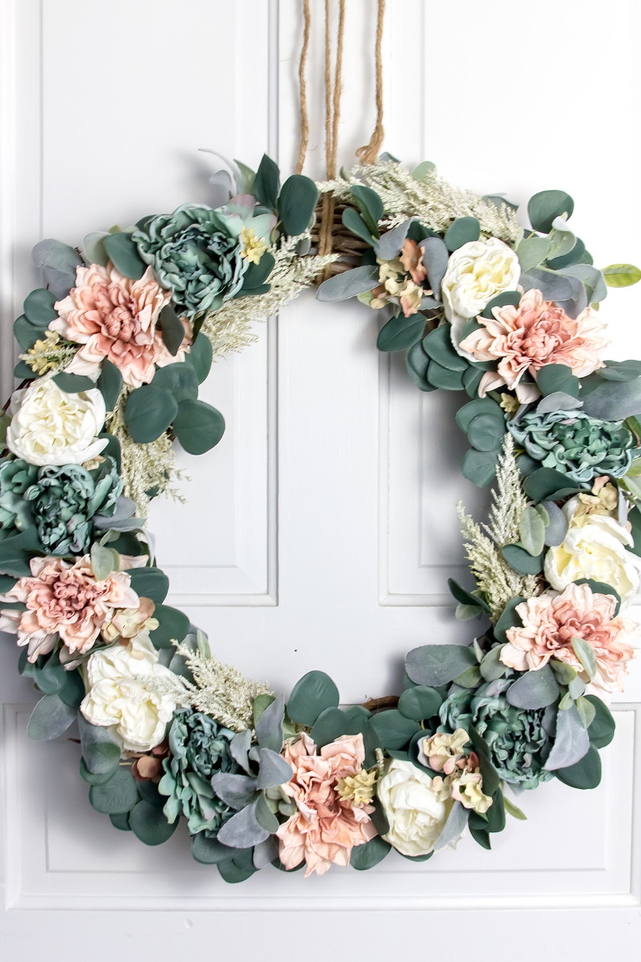 a vintage diy floral wreath with dusty pink, blue, and white flowers