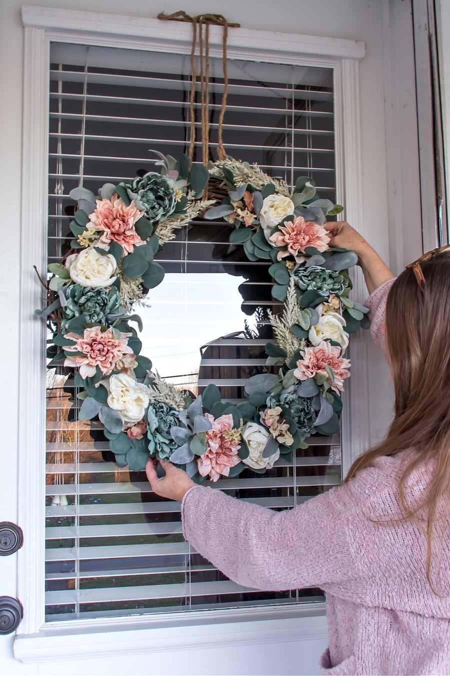 A diy floral wreath with dusty pink, blue, and white flowers.