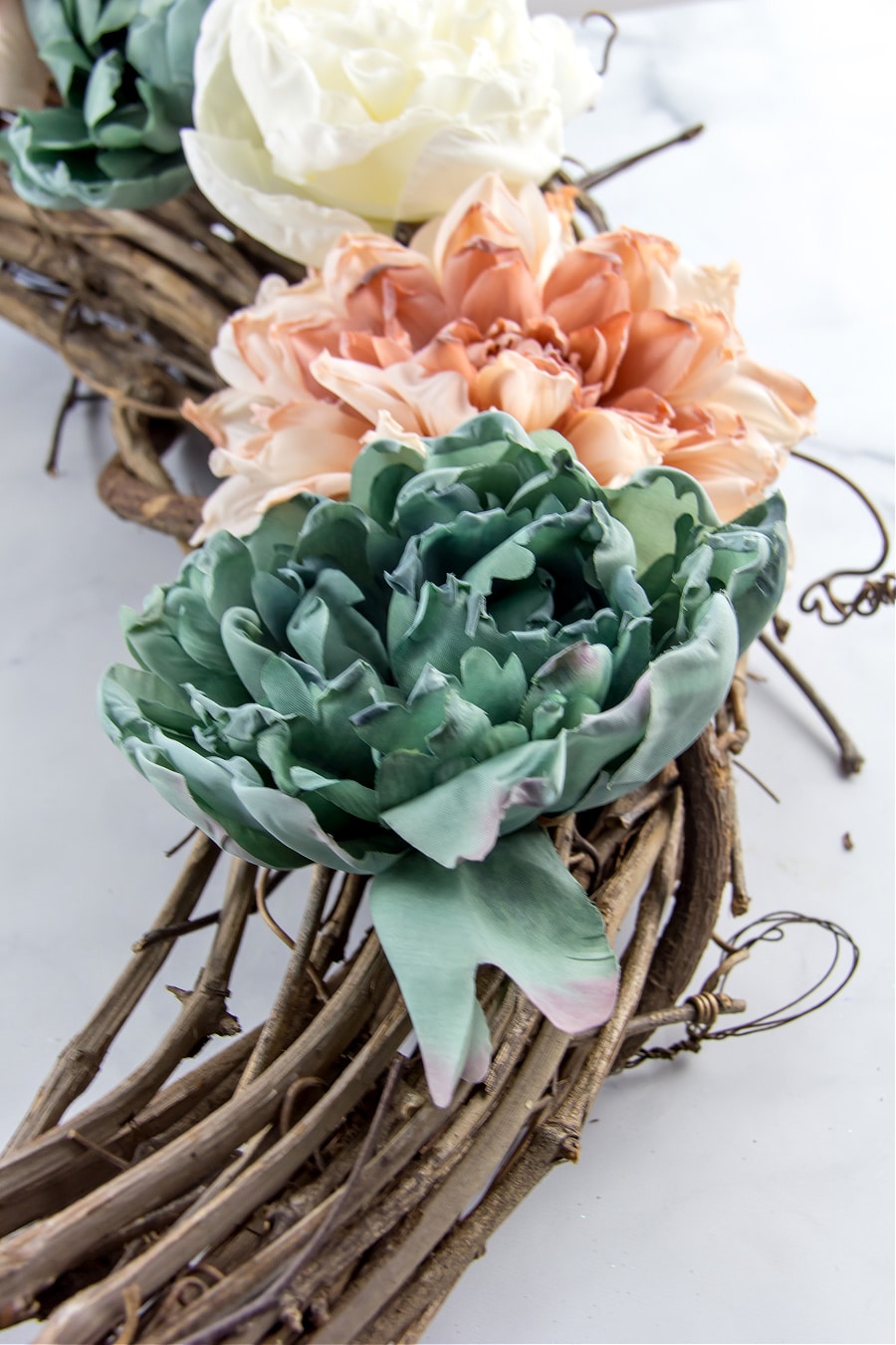 blue, pink, and white flowers glued to a grapevine wreath