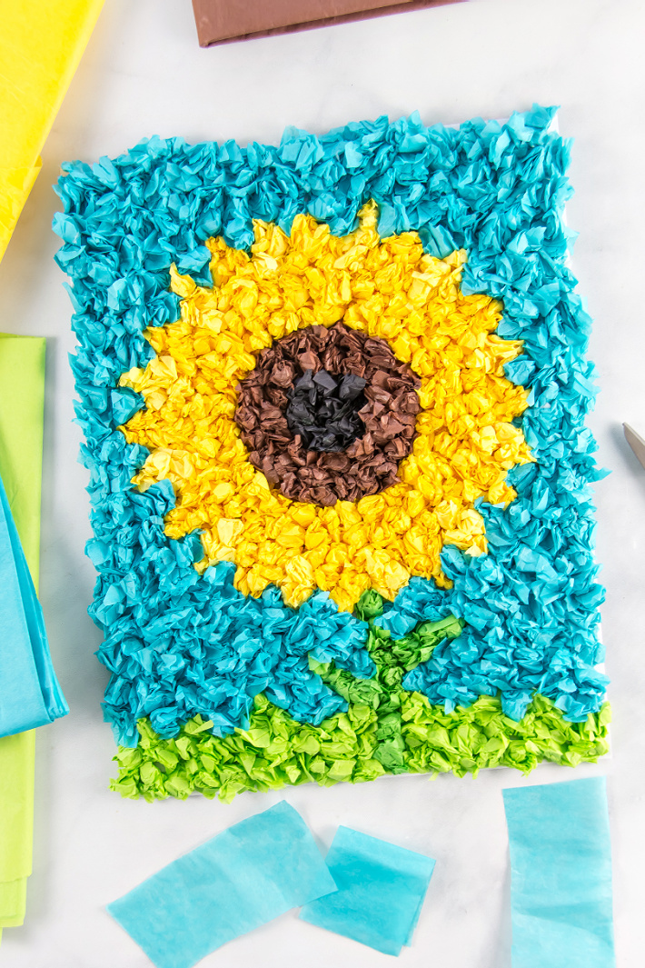 Tissue paper scrunched up into balls and attached to recycled cardboard to make a tissue paper sunflower craft.