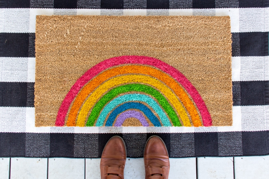 A hand-painted bright and colorful rainbow doormat.