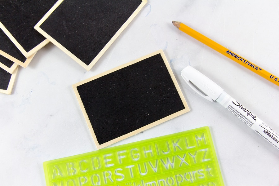 Wood chalkboard, a white Sharpie, and letter stencils to make bathroom organization labels.