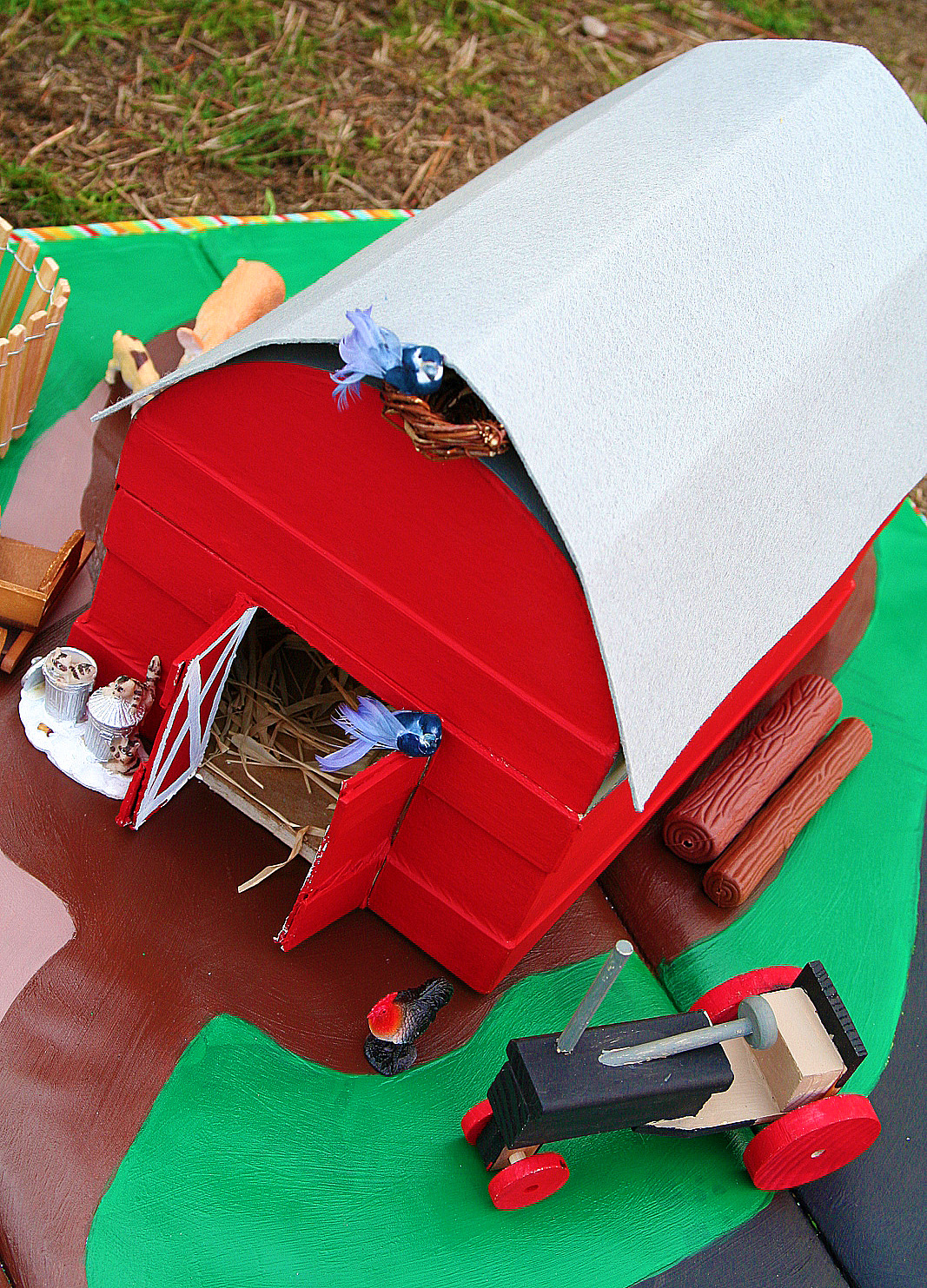 A paper mache chest turned into a barn with a wood tractor and miniatures.