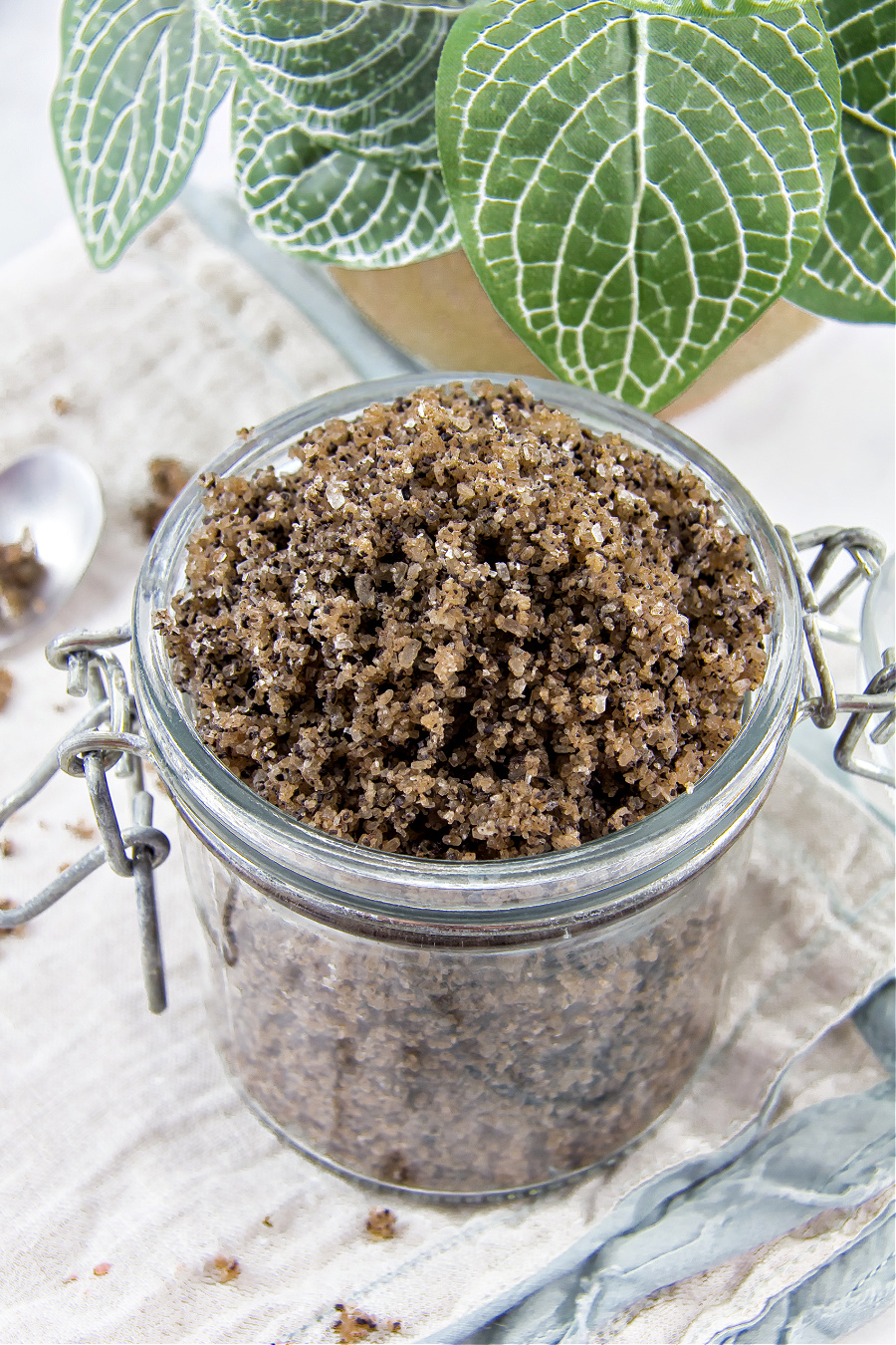 A jar of homemade coffee and epsom salt scrub with coconut oil.